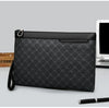 Black checkered clutch bag with zip-top closure, wrist strap, and smooth top trim